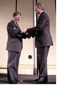 Past treasurer Harry Rutledge, FAIA, (left) receives his citation and a shovel from current treasurer Doug Steidl, FAIA, for his "groundbreaking leadership in reestablishing the AIA's financial stability." (Photo by M. David Williams)