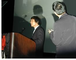 Ando (left) addresses the audience with his interpreter at the ready.