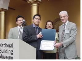 McGraw-Hill Construction President Norbert Young, FAIA (right) presents an ACE scholarship certificate to John Martinez, flanked by his proud parents, at the Washington, D.C., ACE Mentor Program scholarship breakfast May 29, 2002.