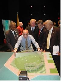 Architect Frederic Schwartz, AIA, explains the “Empty Sky" memorial design to New Jersey Gov. James E. McGreevey (red tie) and competition organizer Tom Moran of the N.J. State Council of the Arts (between Schwartz and the governor). Frank Gallagher, Liberty State Park director, is in red in the background.