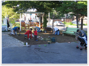 Volunteers finish preparing a garden plot for planting.