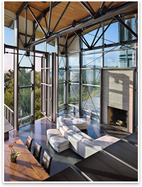 The main living space of the house features wood lining on the ceiling, operable windows, and views of Puget Sound.