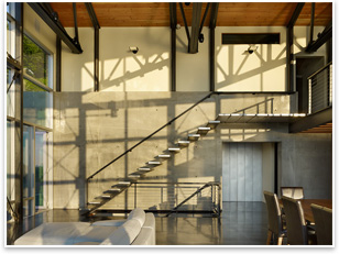 A steel floating stair leads to the master bedroom level.